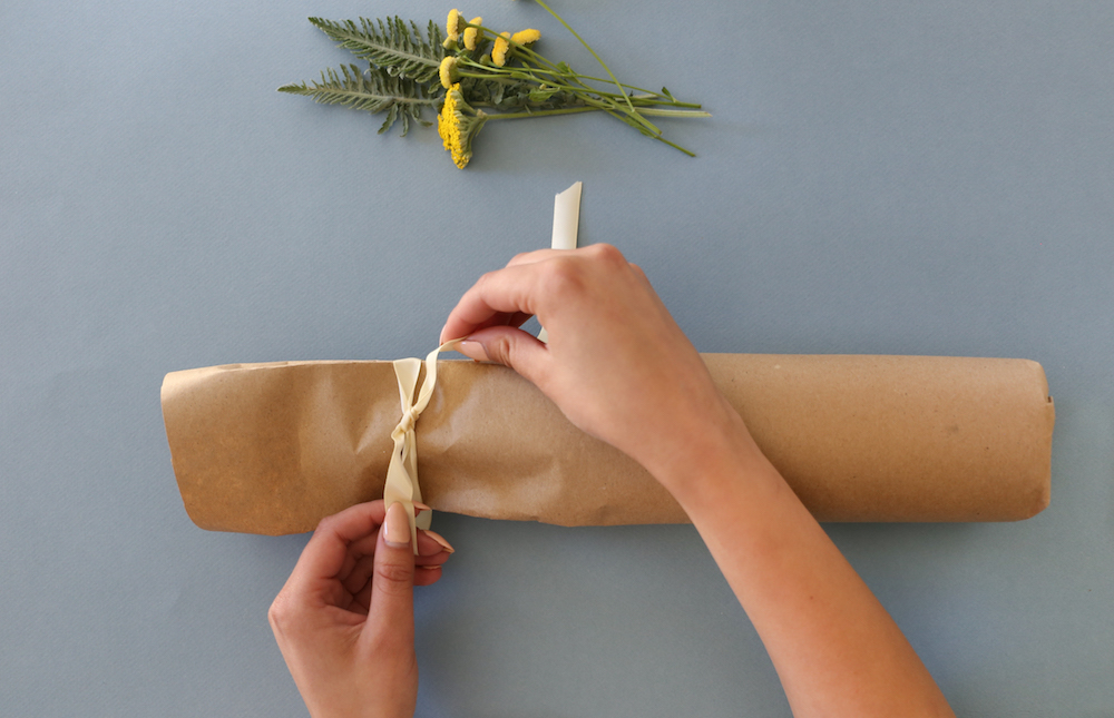 Craft paper being tied with ribbon